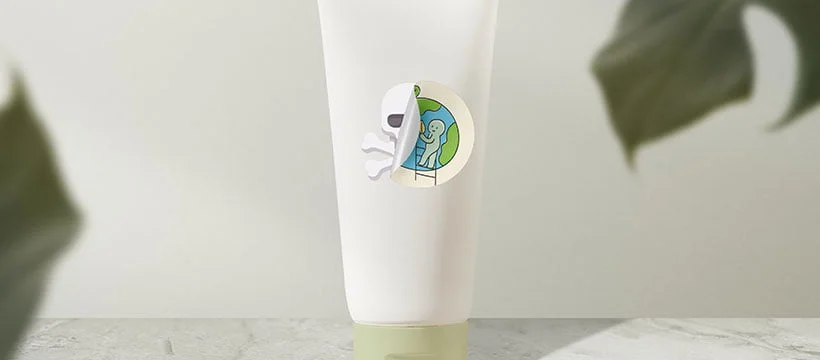 Embalagem branca sobre uma mesa com uma etiqueta adesiva de planeta Terra descolando e por baixo da etiqueta tem uma caveira que representa o greenwashing nas embalagens de produtos.